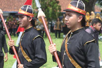 Professional waitstaff in black and gold uniforms serving guests at an elegant event.