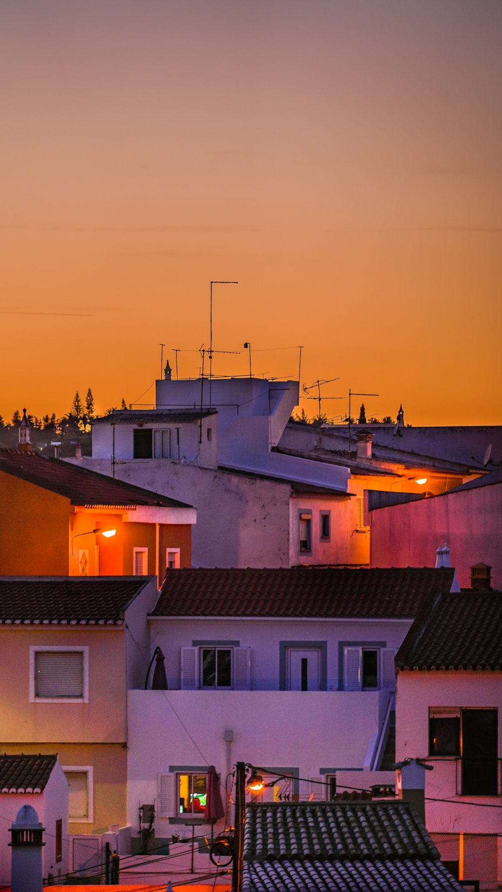 a view of a city at sunset with buildings lit up