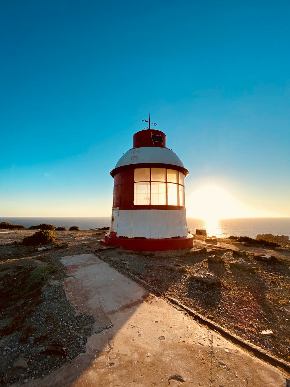 a light house sitting on top of a hill near the ocean