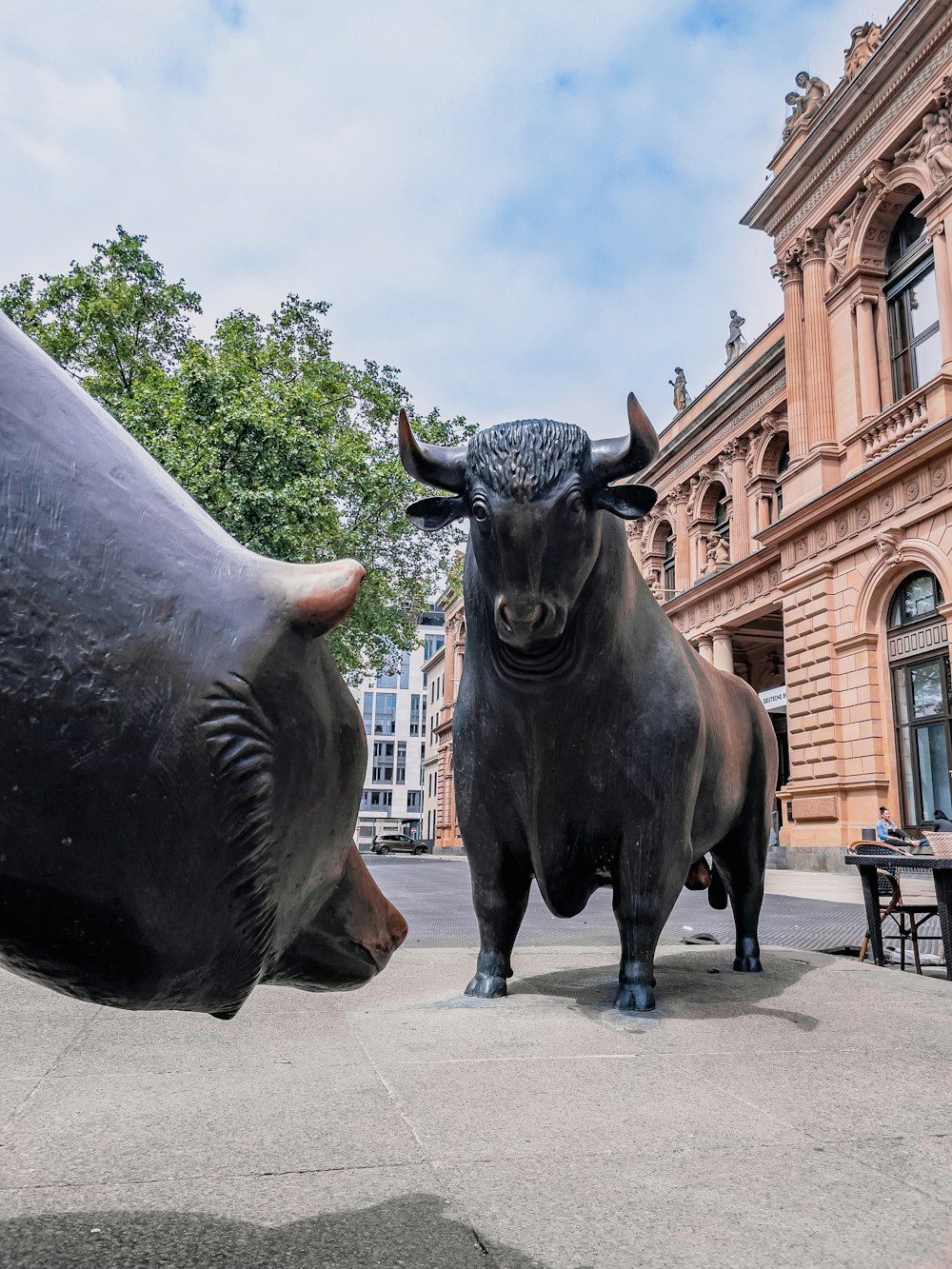 una statua di un toro e una testa di toro di fronte a un edificio