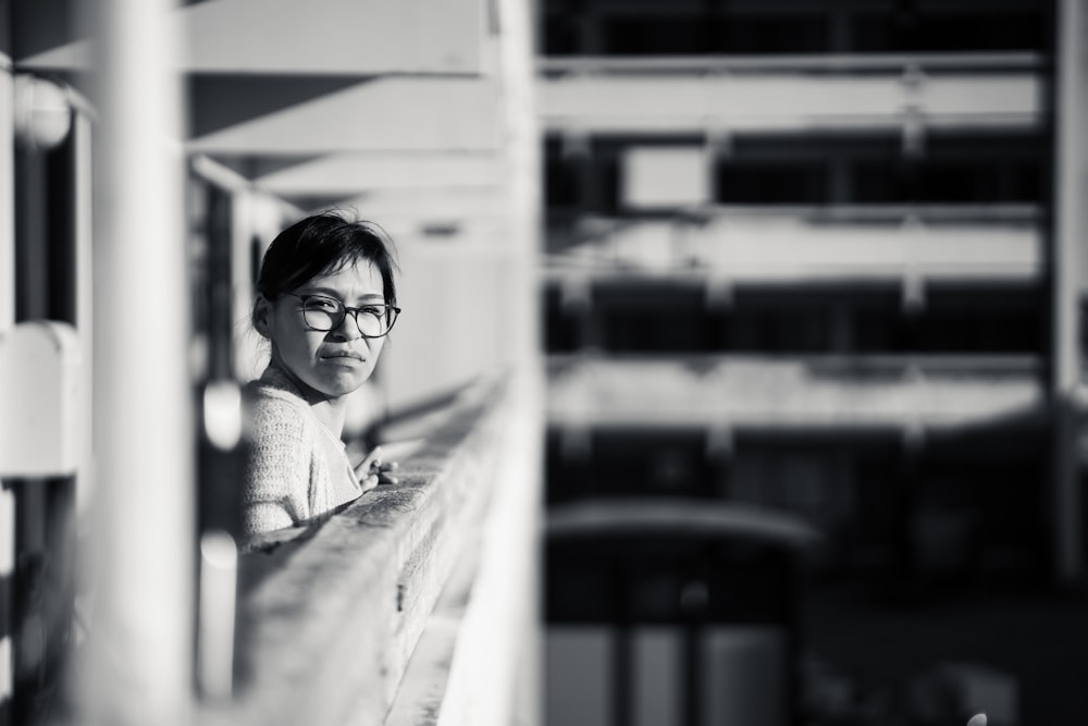 a black and white photo of a woman sitting on a bench