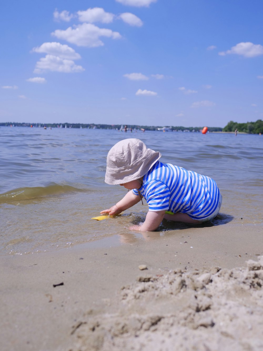 a little boy playing in the sand at the beach