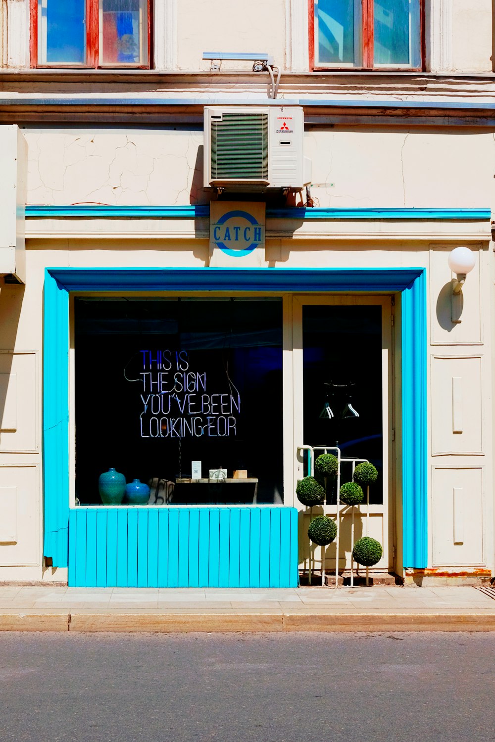 a store front with a blue window and a sign that says the sun is the