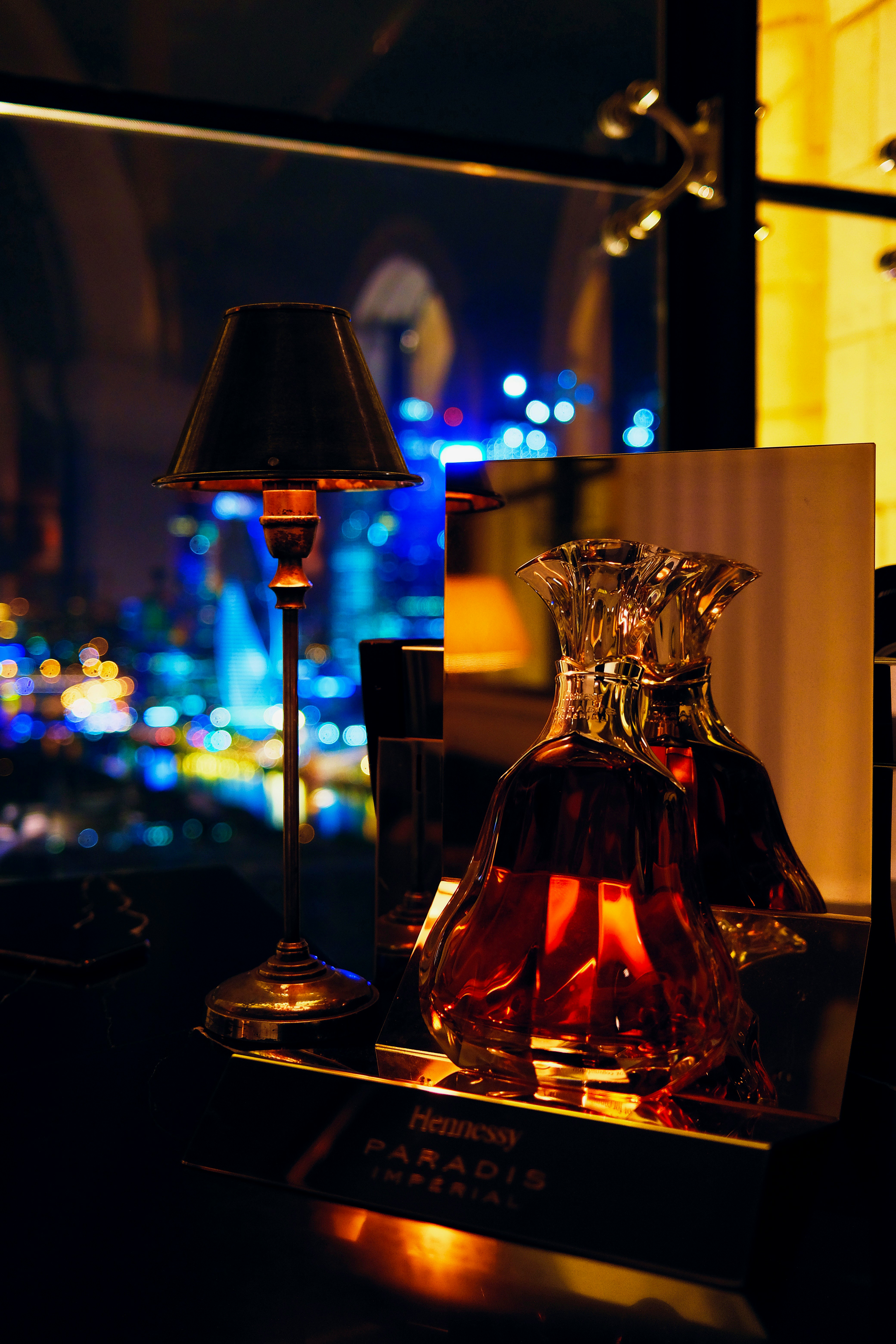 a table with a lamp and a bottle on it