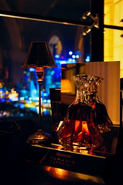 a table with a lamp and a bottle on it