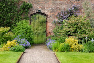 a garden with a brick wall and a gate