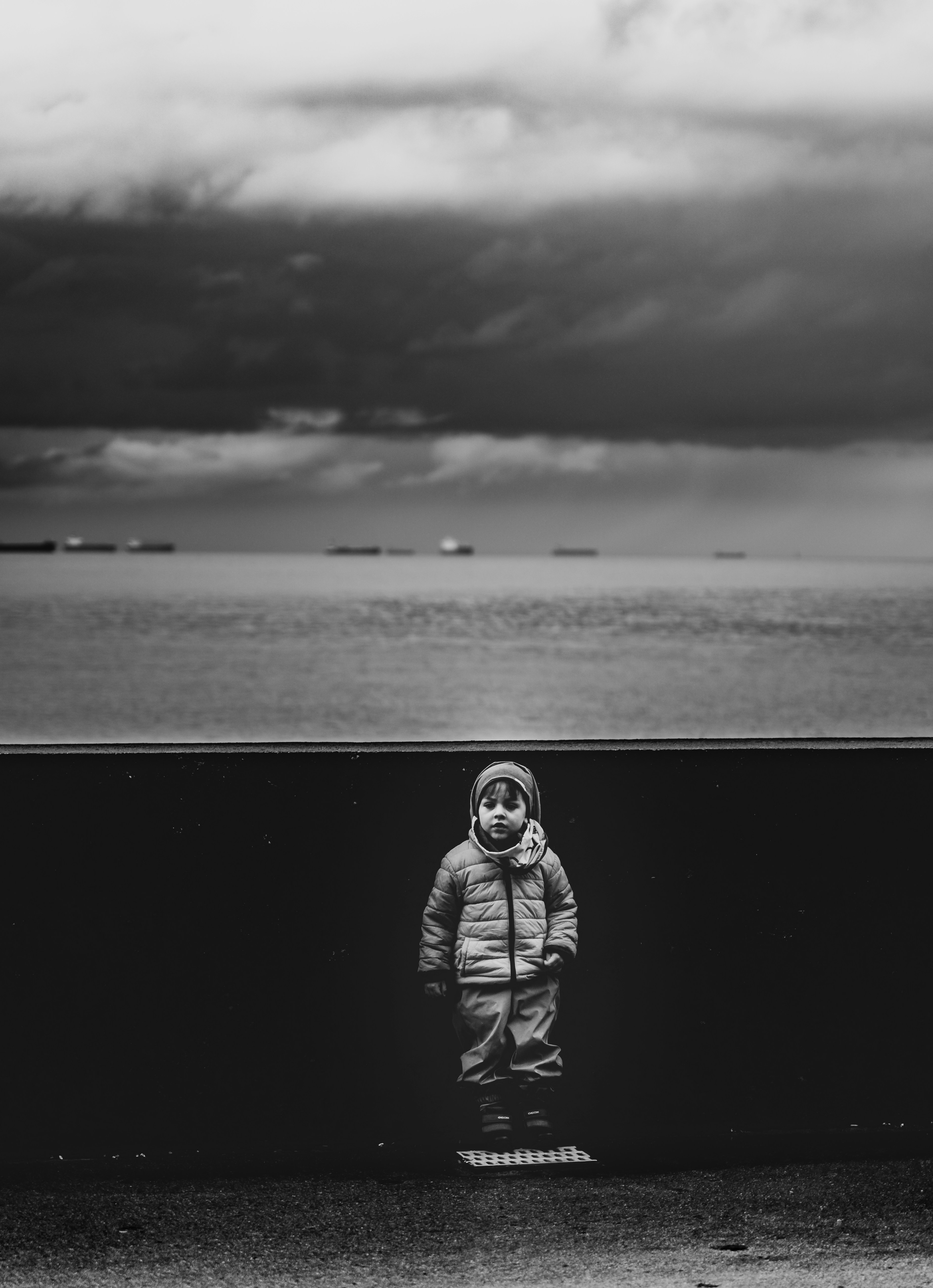 a-black-and-white-photo-of-a-person-standing-in-front-of-a-body-of