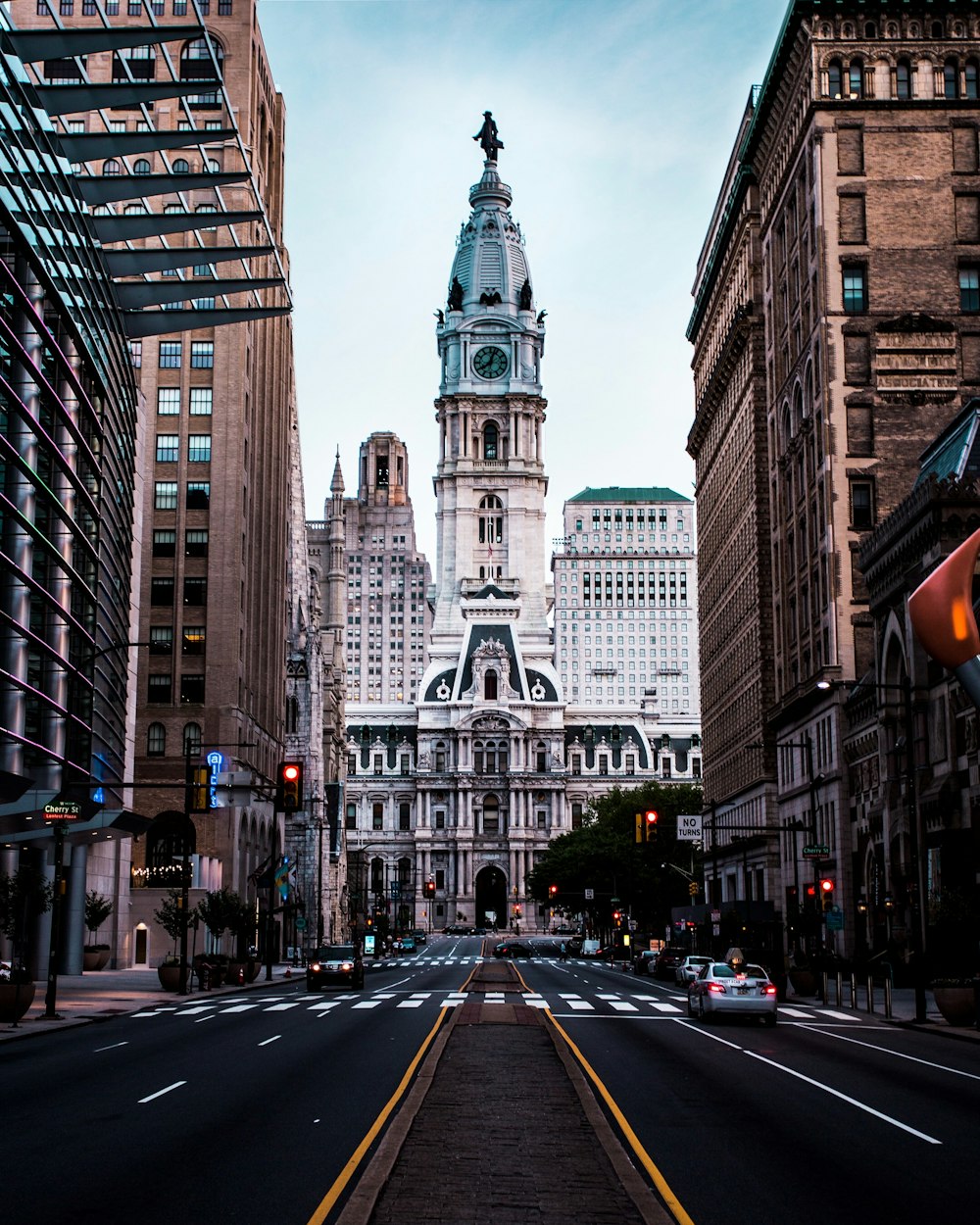 a city street with tall buildings and a clock tower