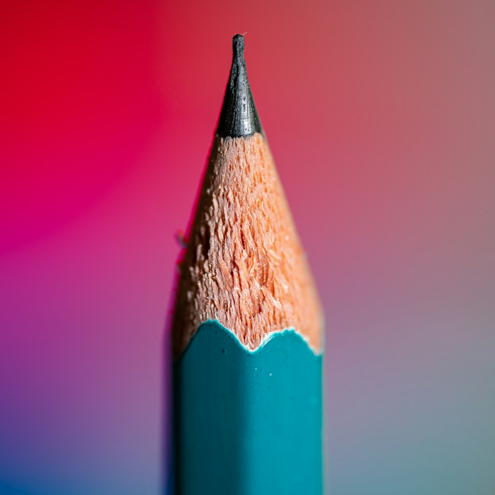 a close up of a pencil with a colored background