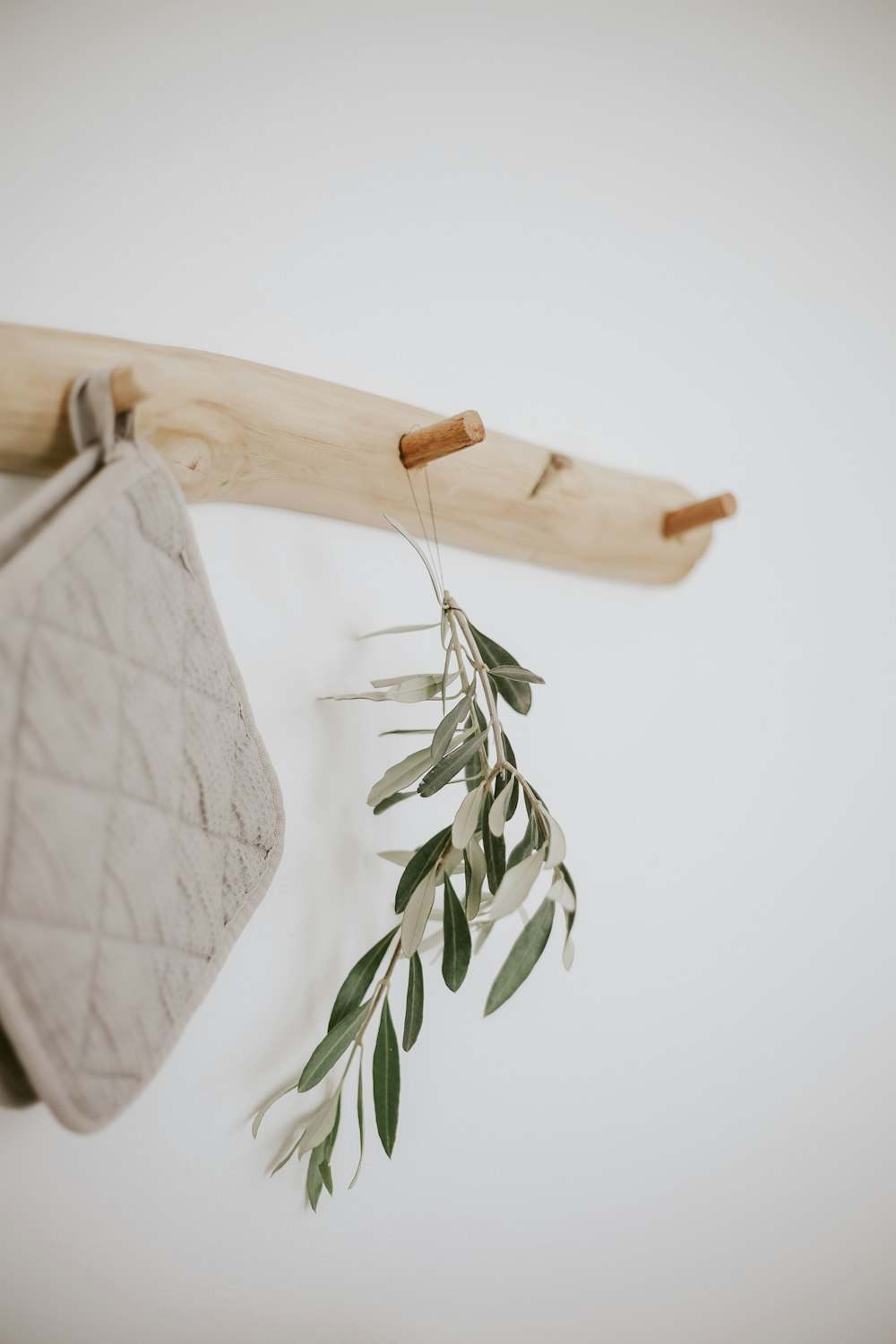 a bag hanging on a wall next to a wooden hanger