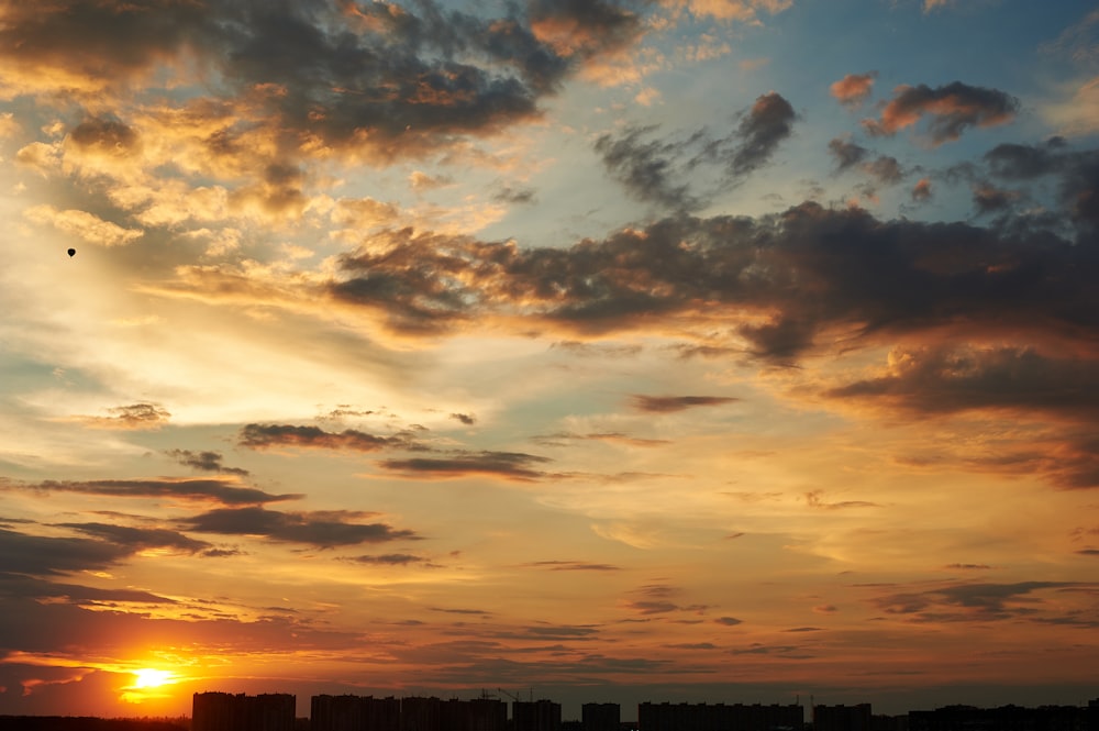 the sun is setting over a city with tall buildings