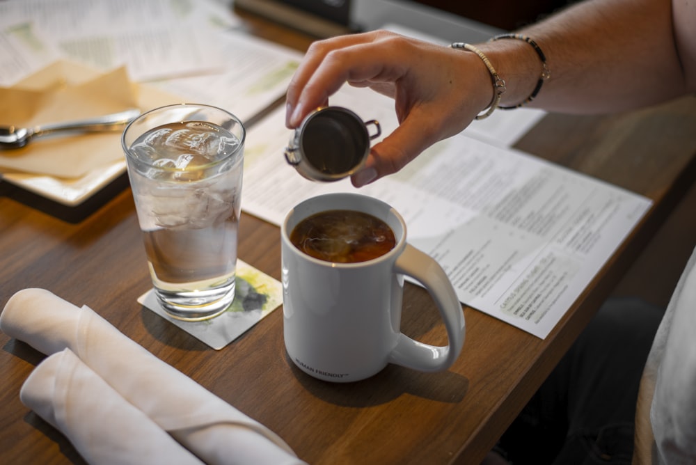 a person is pouring something into a cup