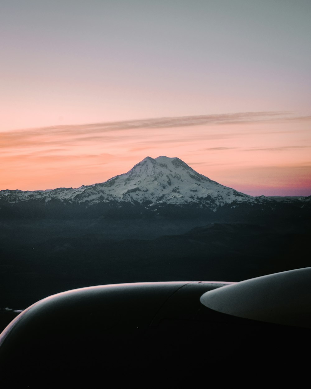 a view of a snow covered mountain from an airplane