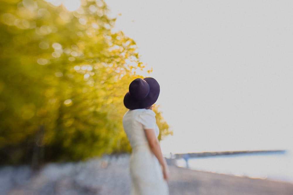 Una mujer con un vestido blanco y un sombrero negro