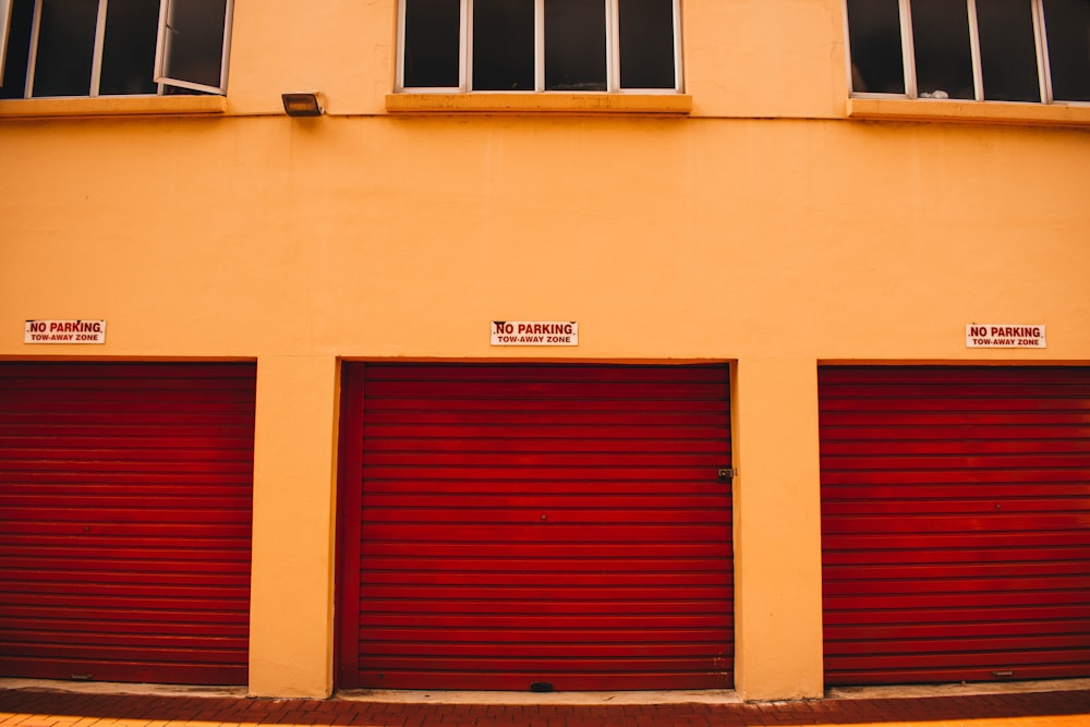 a red fire hydrant sitting in front of a yellow building