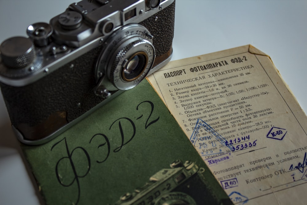 an old camera sitting on top of a book