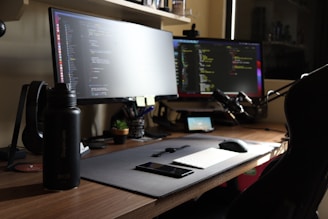 a computer desk with two monitors and a mouse