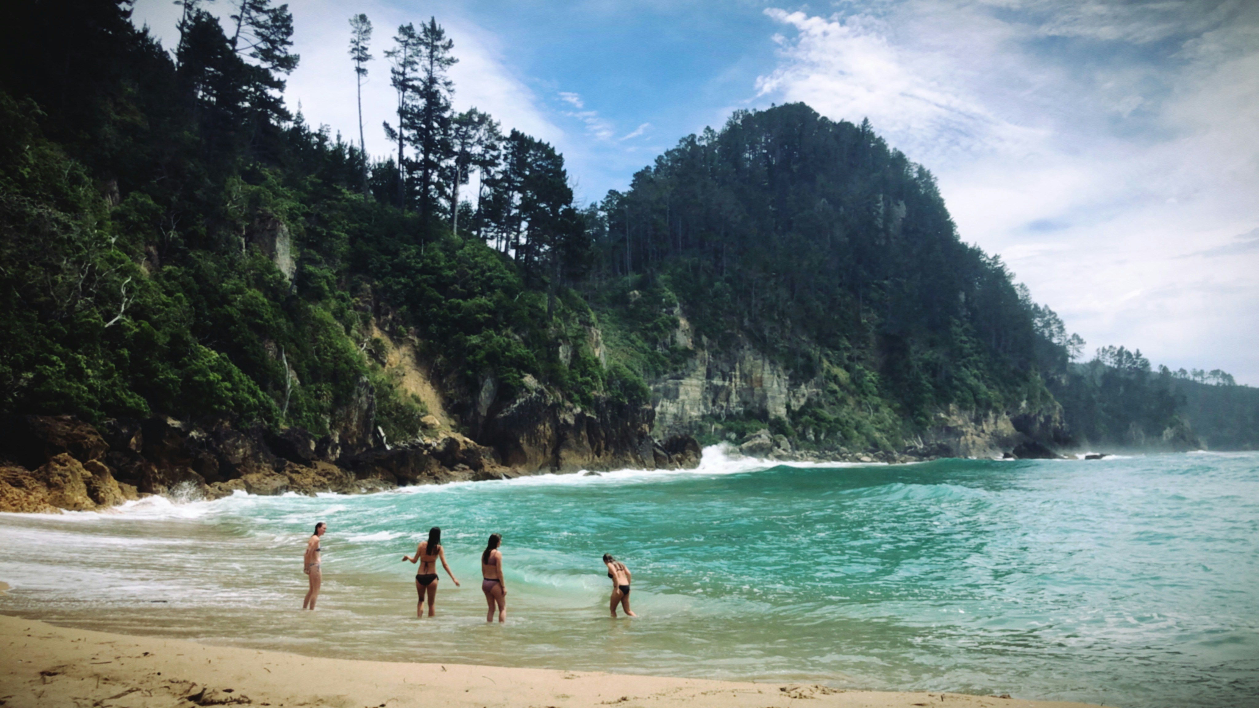a group of people standing on top of a sandy beach