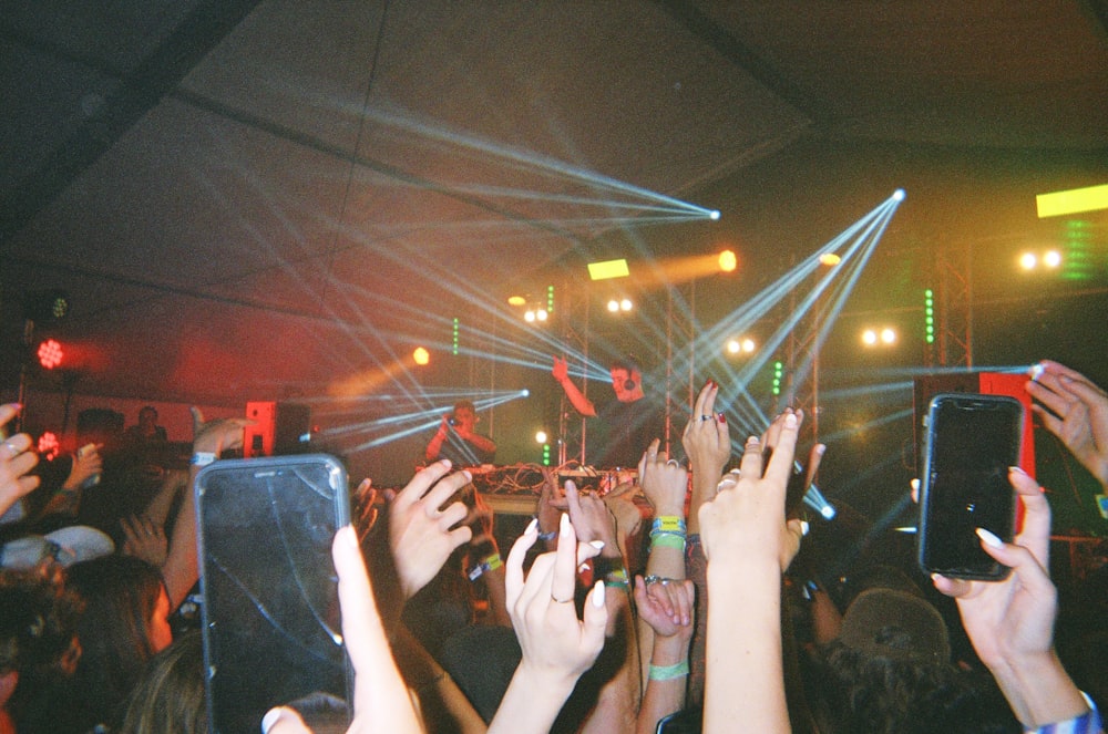 a crowd of people holding up their cell phones