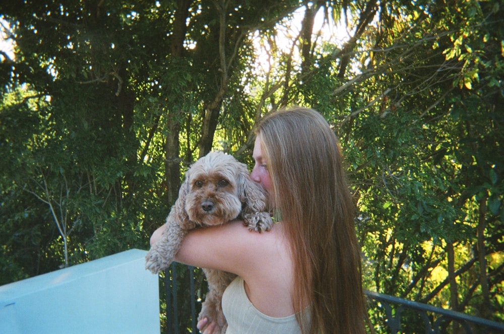 a woman holding a small dog in her arms