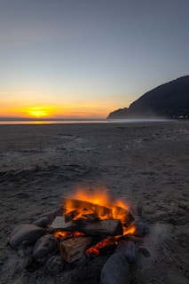 A vibrant beach sunset with travelers enjoying a bonfire