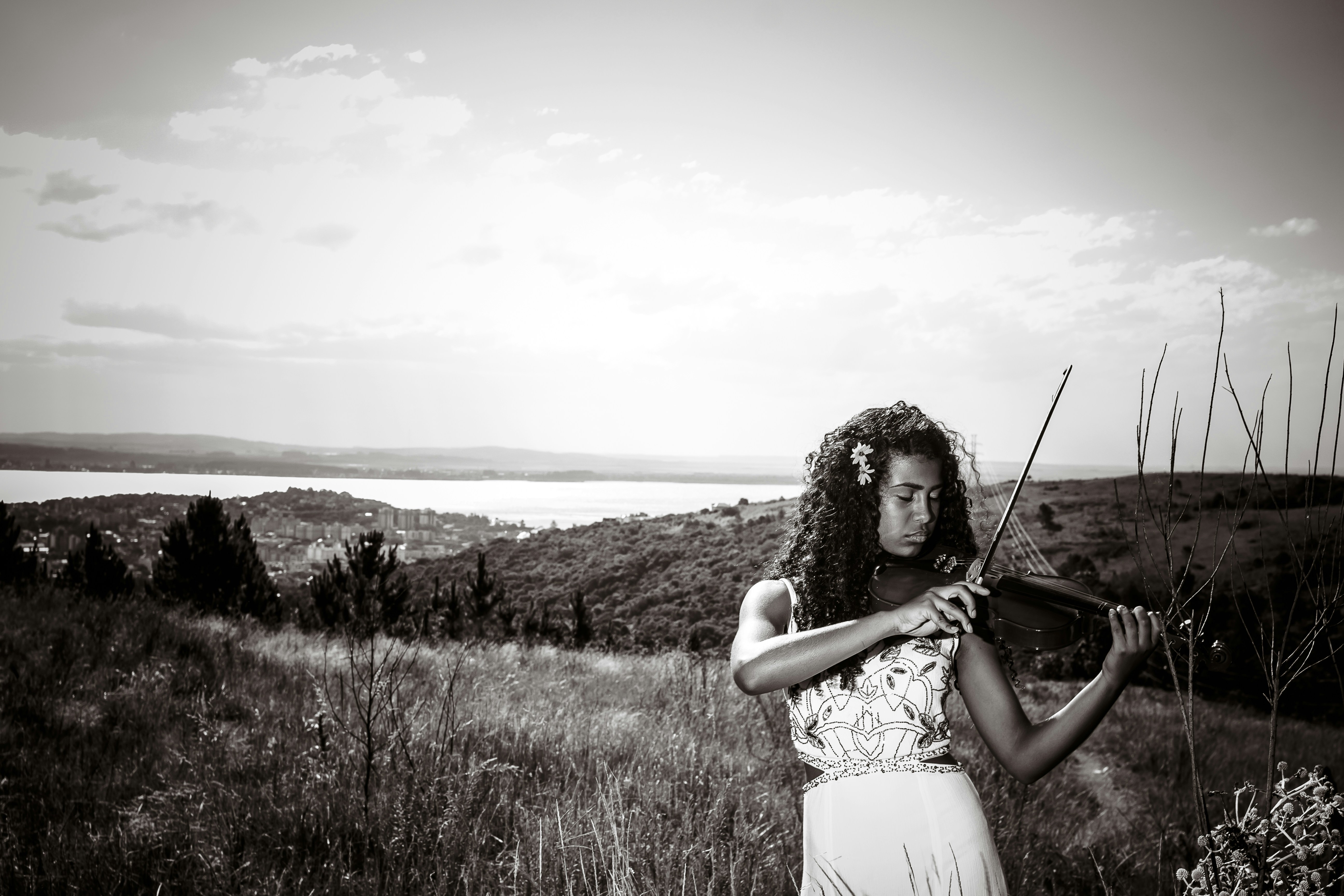 A woman holding a violin in a field photo – Free Woman Image on Unsplash