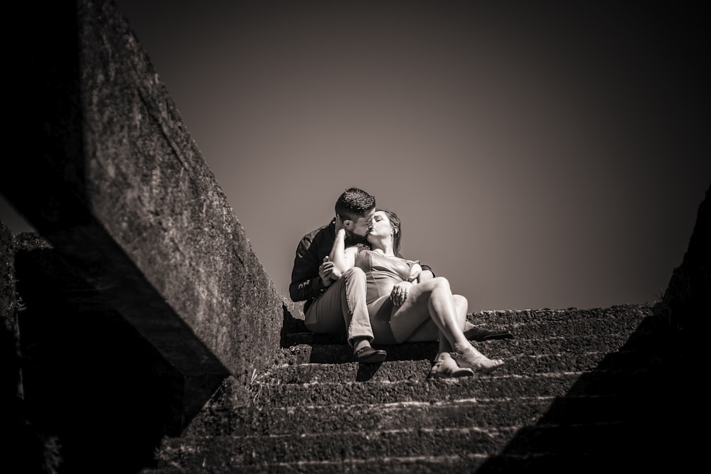 a couple of people sitting on top of a set of stairs