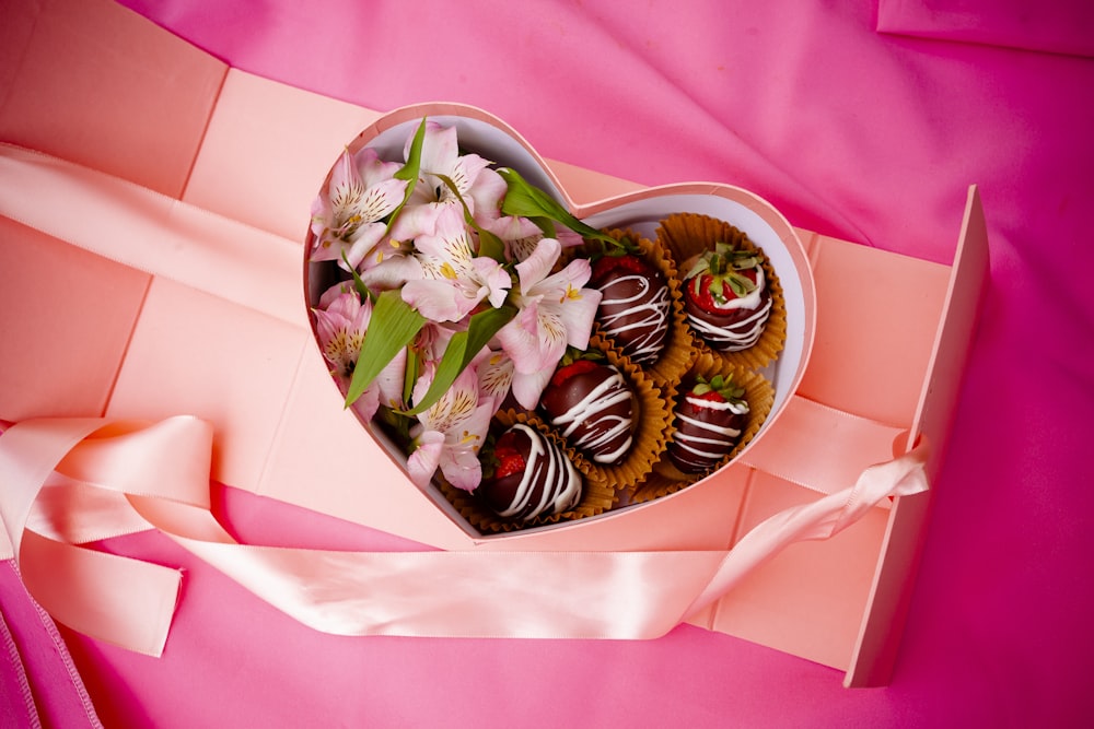 uma caixa em forma de coração cheia de morangos cobertos de chocolate