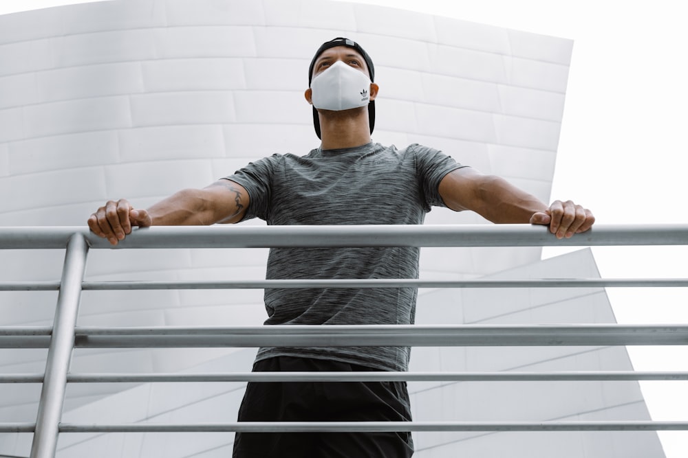 a man wearing a mask standing on a railing