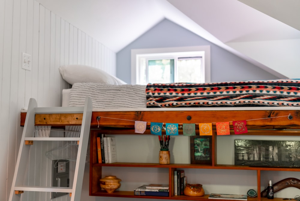 a loft bed with a ladder and bookshelf