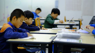 a group of children sitting at desks in a classroom