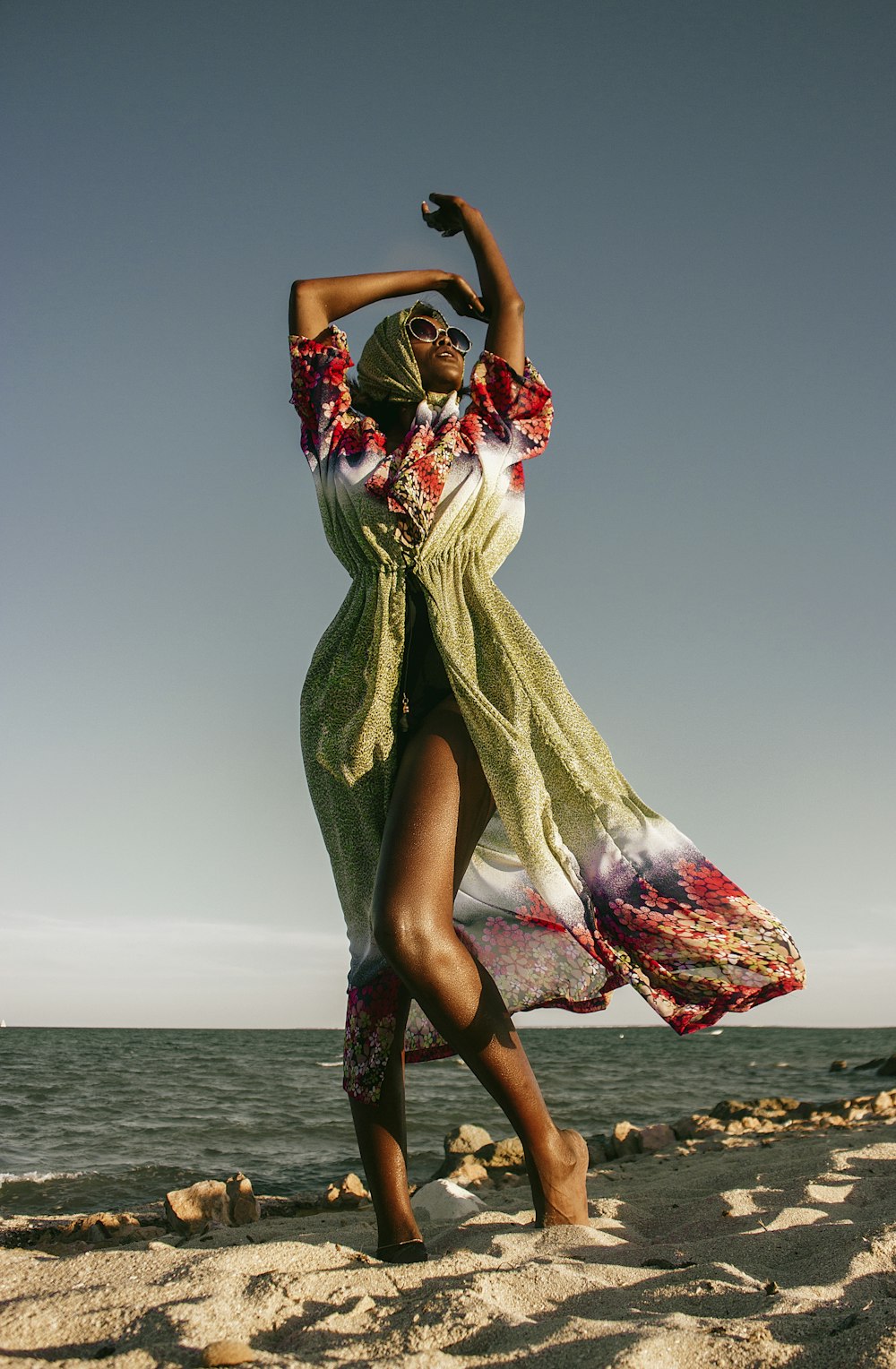 Una mujer bailando en la playa con un vestido