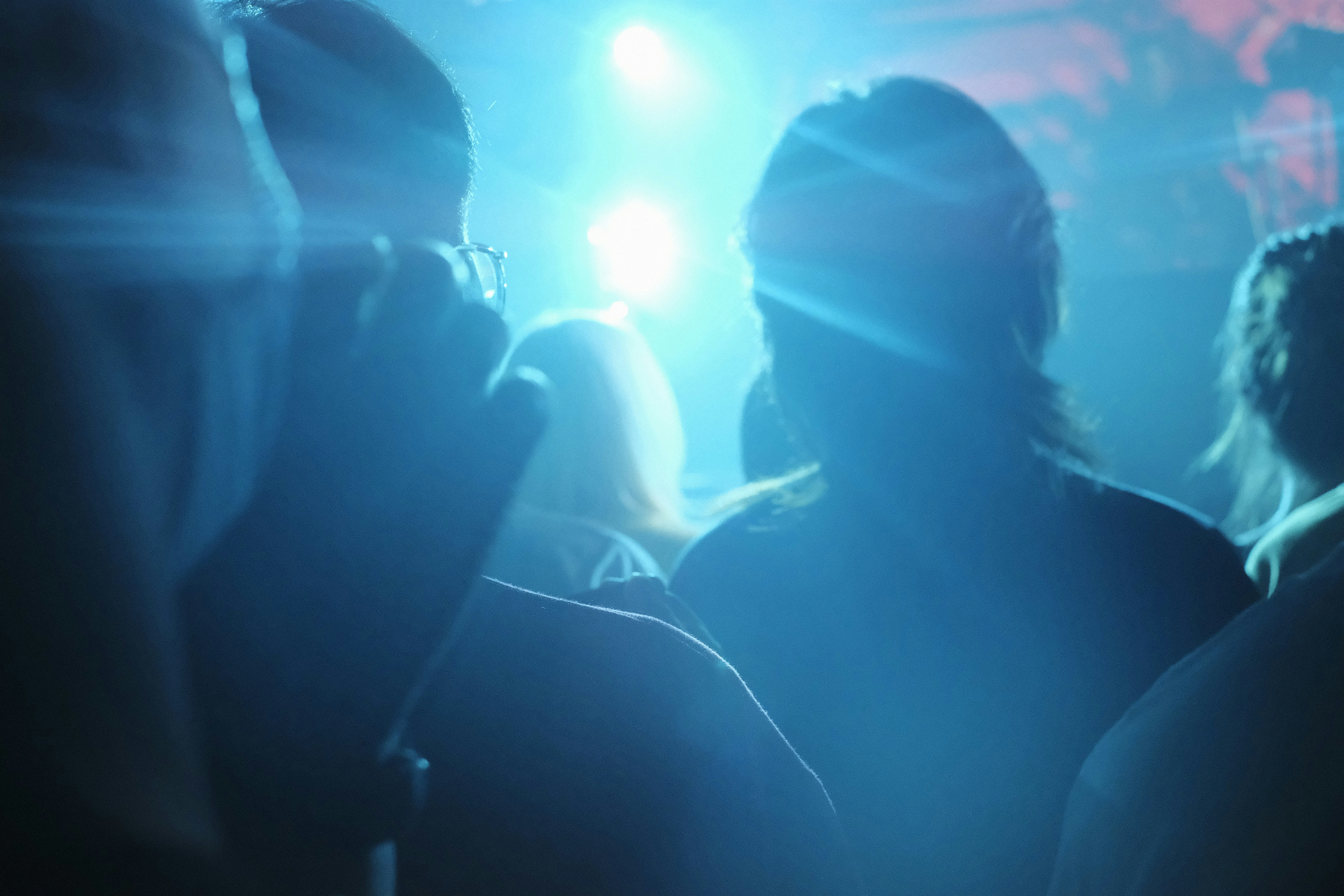a group of people standing in front of a blue light