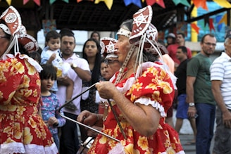 Traditional dance performance featuring woman in red and yellow floral dress, embodying cultural 