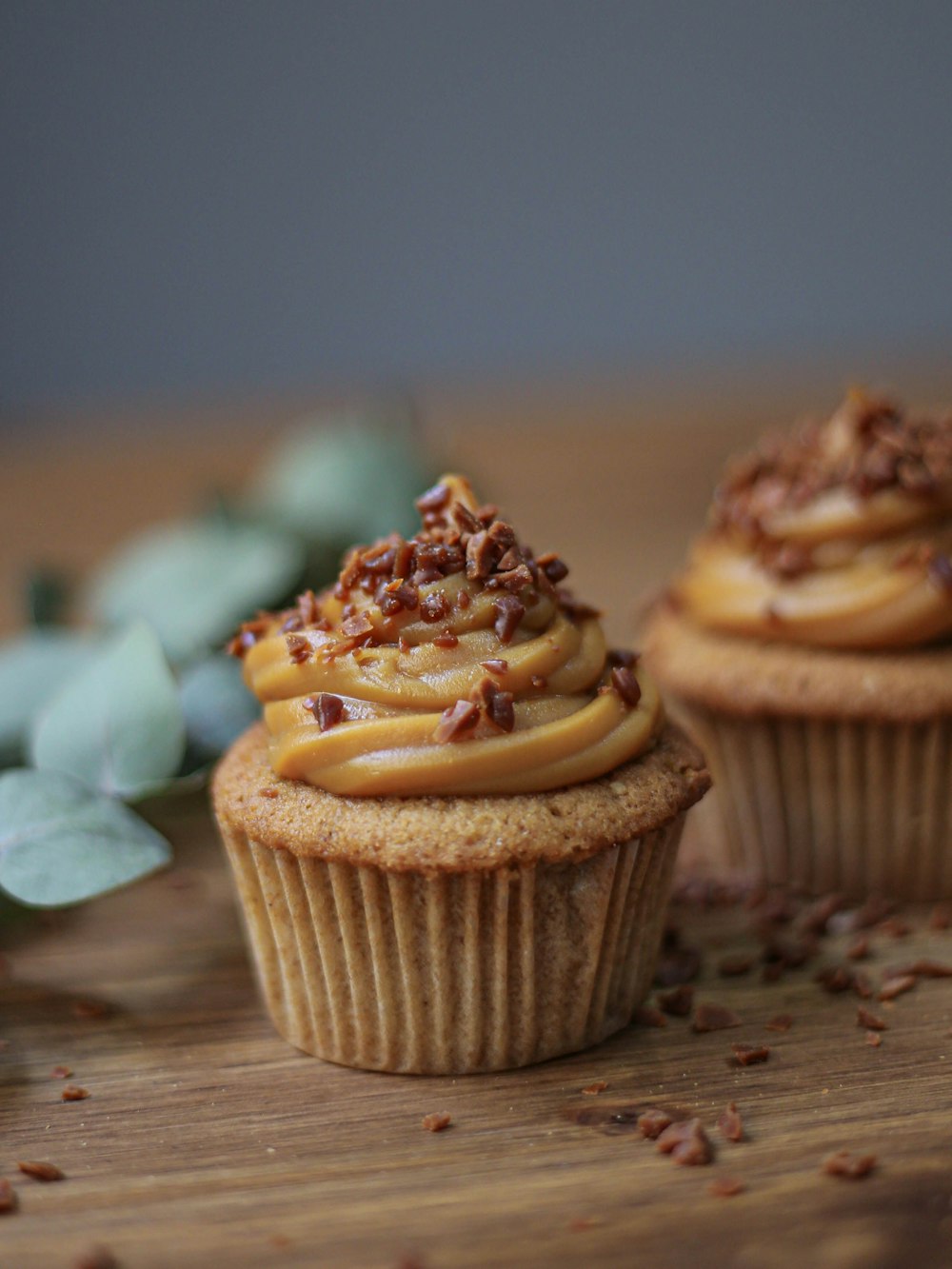 a couple of cupcakes sitting on top of a wooden table