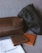 The image features two leather pouches, one dark brown and one black, positioned on a fabric surface. In front of them are two leather wallets, one brown and the other tan, along with a branded white cloth bag labeled 'blackduck'. The items appear to be high-quality leather goods.