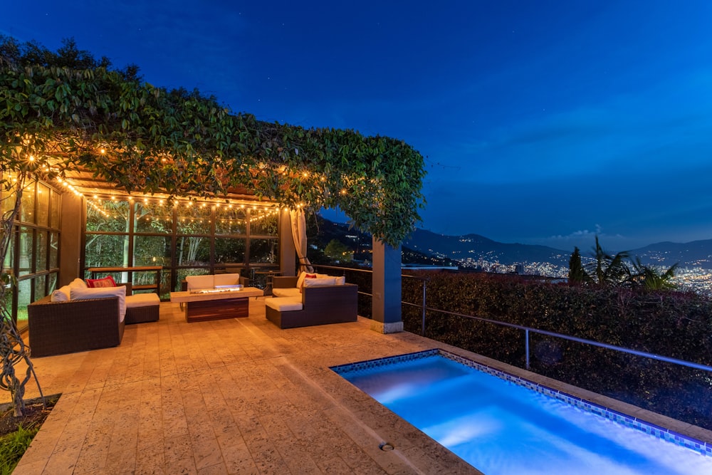 a patio with a pool and seating area