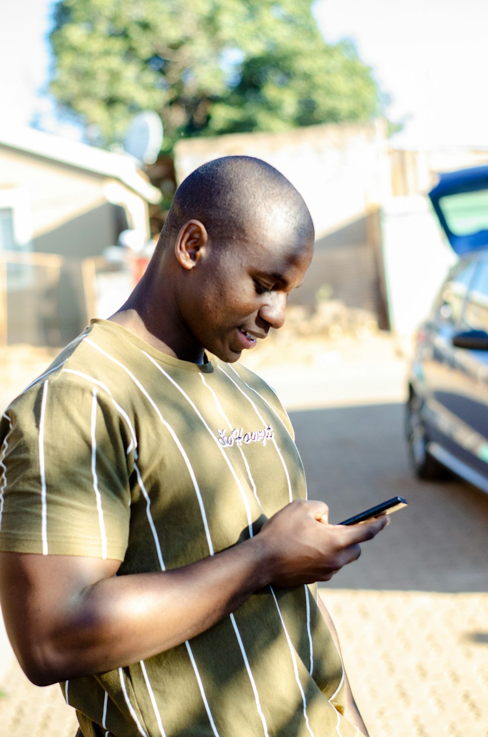 a man in a green shirt looking at his cell phone