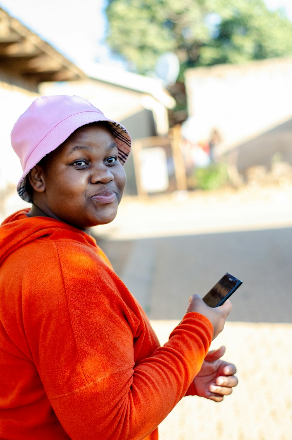 a woman in a pink hat holding a cell phone