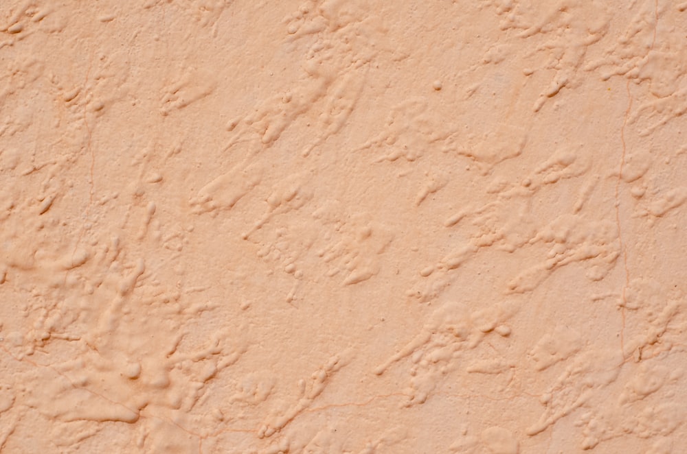 a close up of a tan stucco wall