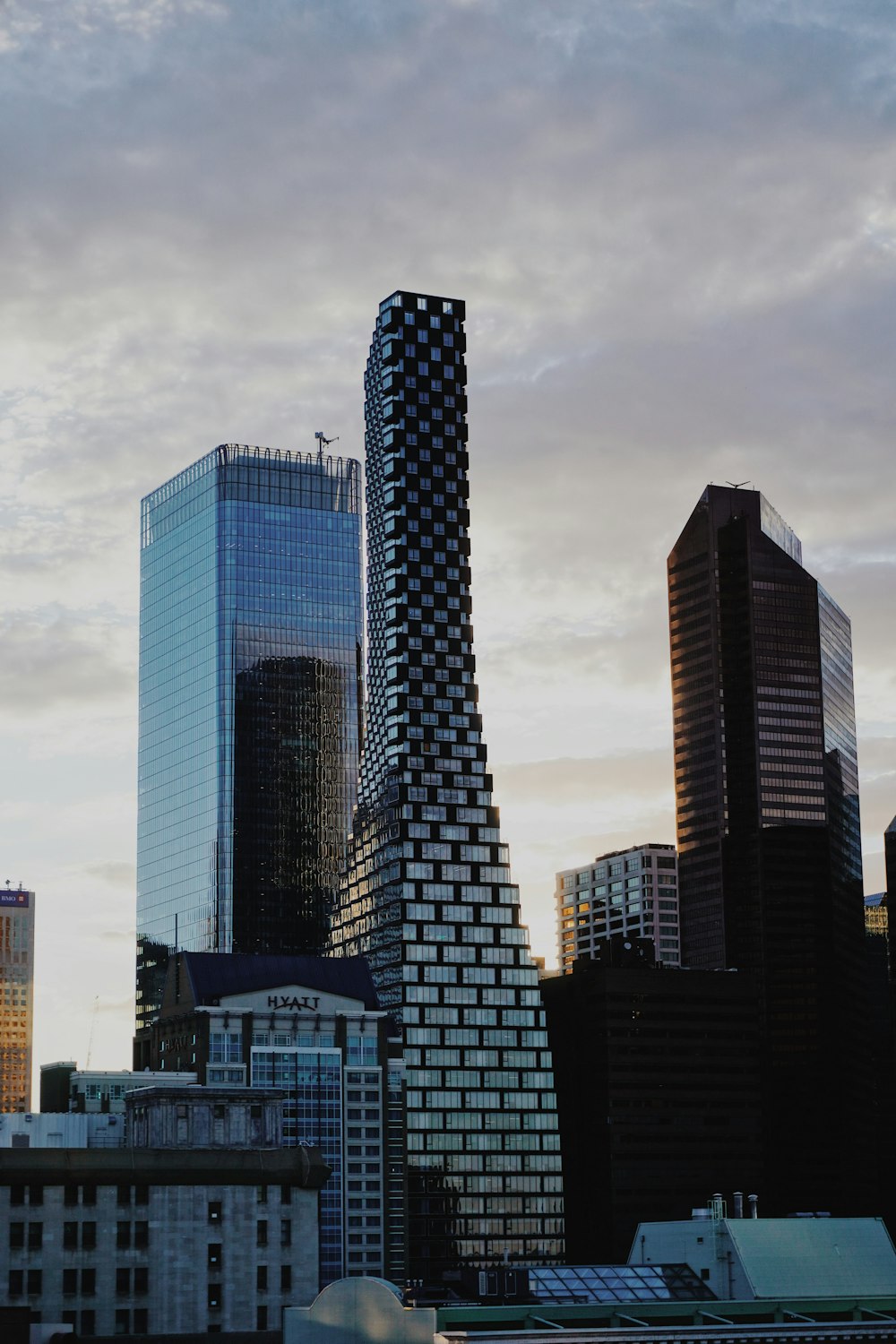 a city skyline with tall buildings and a cloudy sky