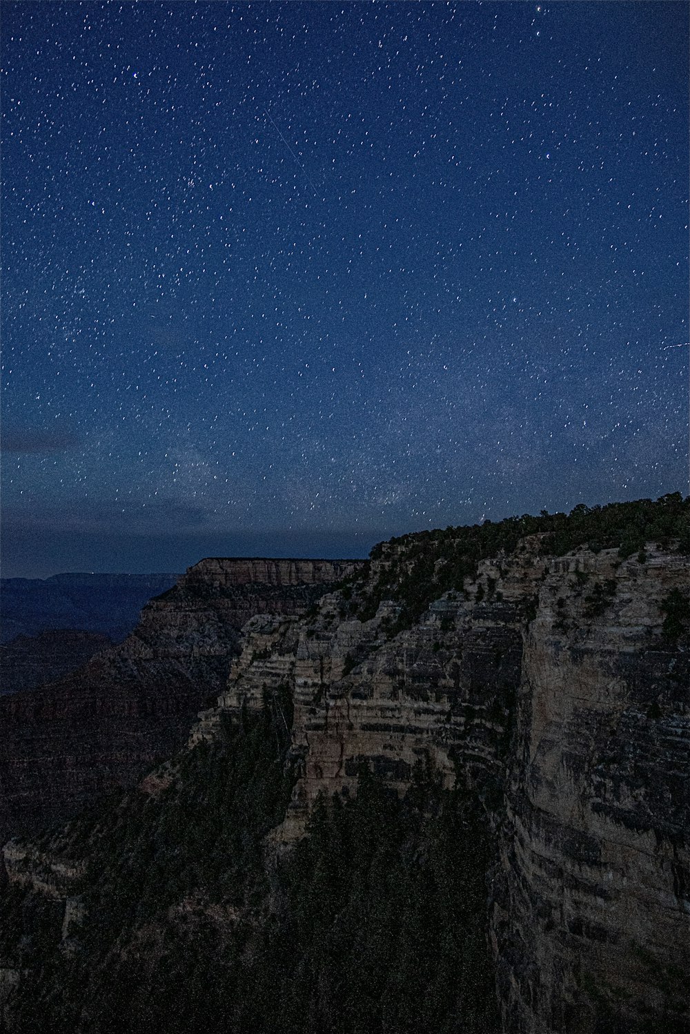 a view of the night sky over a canyon