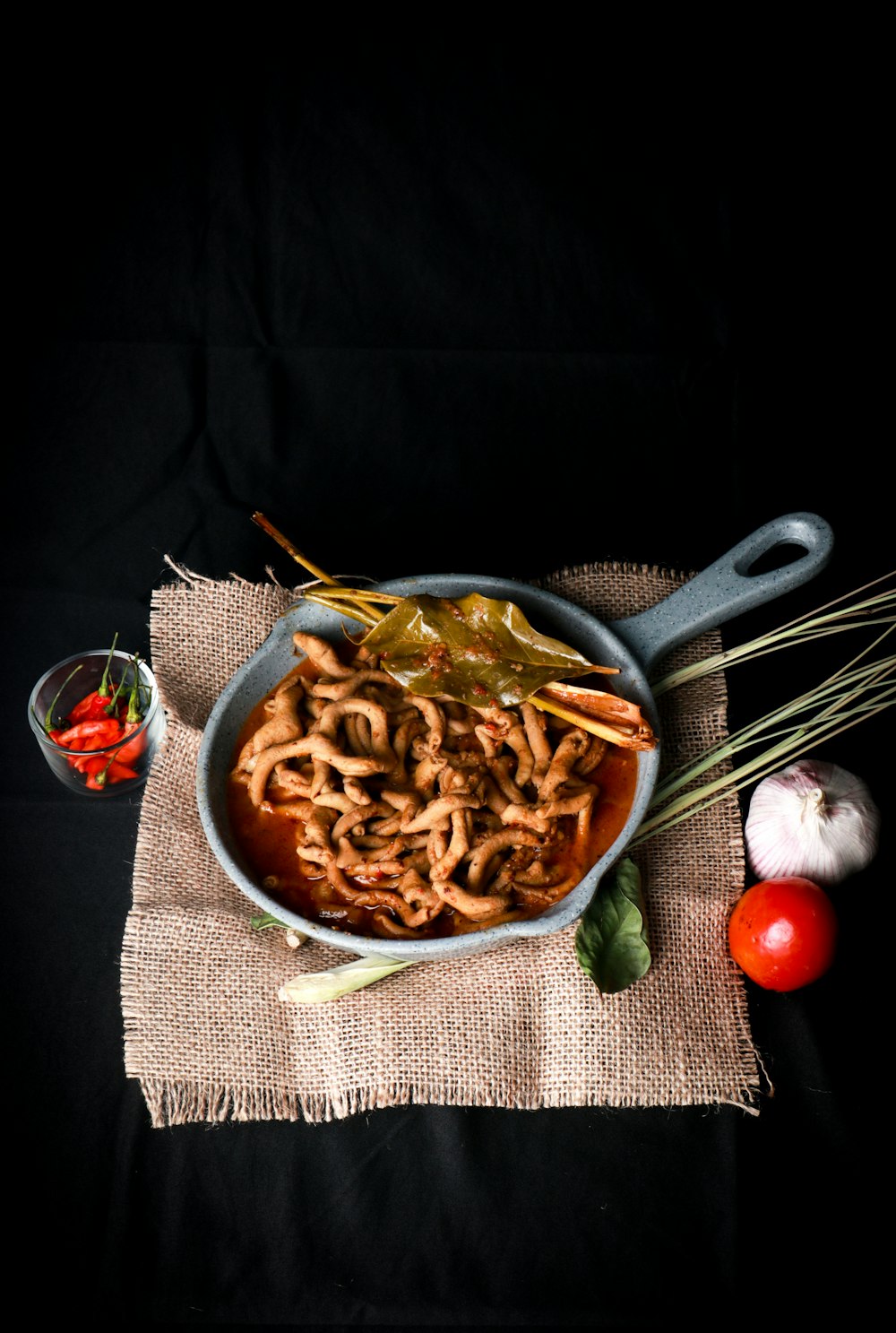a bowl of noodles and vegetables on a cloth