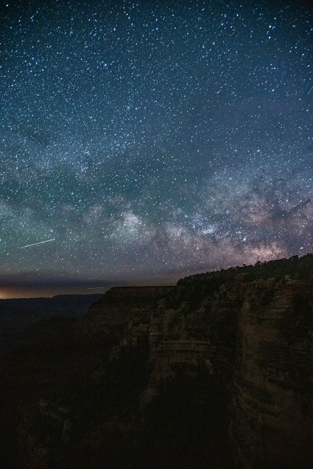 the night sky is filled with stars above a mountain