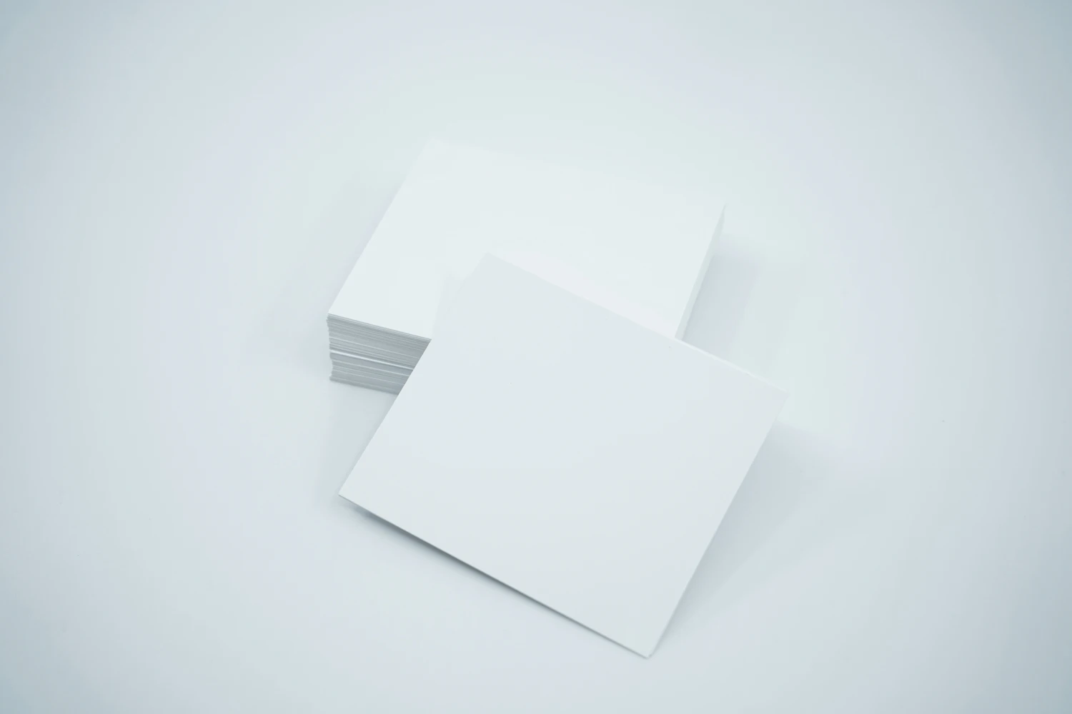 A stack of blank white cards on a plain surface
