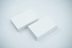 A polished metal card holder open to reveal neatly stacked business cards inside.
