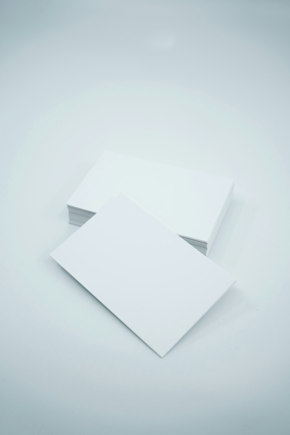 Dos hojas de papel en blanco sobre fondo blanco
