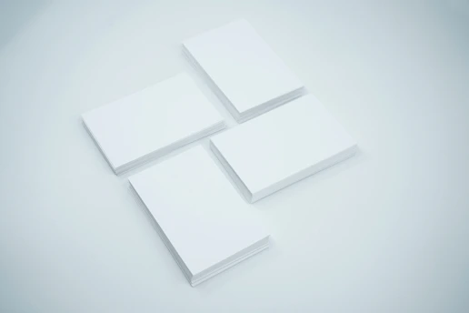 A neatly arranged stack of rare trading cards on a white surface with blueprint blue shadows softly cast around them.