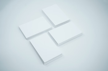 Four neatly stacked piles of blank white cards are arranged on a light surface.