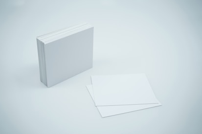 a white book with a blank cover next to it